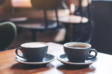 Fotobehang Closeup image of two blue cups of hot latte coffee and Americano coffee on vintage wooden table in cafe © Farknot Architect