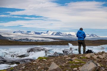 Traveler at the Iceberg lagoon of Fjallsarlon, Iceland.