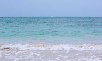 Fototapeta na wymiar Soft wave of blue ocean on sandy beach. background. selective focus. beach and tropical sea white foam on beach. soft focus on bottom of picture.