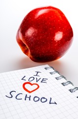 Obraz na płótnie Canvas I Love School Written In Notebook Lying Next To Red Apple Close