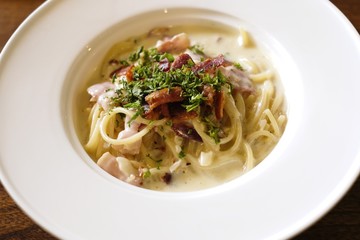 Italian cuisine, Spaghetti Cabana or Spaghetti White Sauce on white dish at restaurant, top view