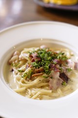 Italian cuisine, Spaghetti Cabana or Spaghetti White Sauce on white dish at restaurant, top view