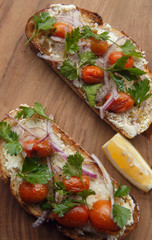 Open sandwich, toast, bruschetta with goat cheese, sun-dried tomatoes and arugula, served on the wooden Board. Healthy eating