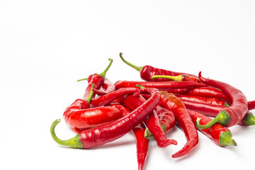 Several red hot chili peppers on a white background