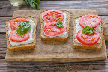 Crostini with toasted gray bread, cottage cheese and slased tomatoes .