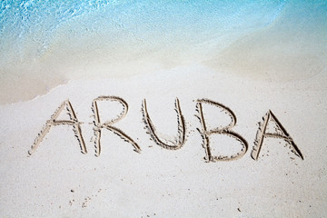 The inscription of Aruba on the beach of white sand - obrazy, fototapety, plakaty