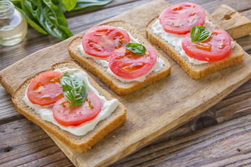 Crostini with toasted gray bread, cottage cheese and slased tomatoes .