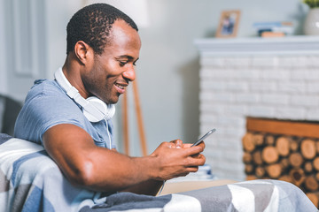 Interesting talks. Attentive young man chatting while sitting on the sofa