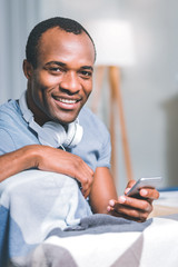 Time at home. Handsome young man waiting for a messagw while sitting in a room