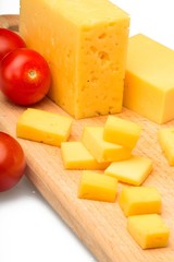 Yellow Cheese and Cherry Tomatoes on the Cutting Board - Close