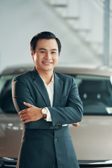 Portrait of happy mature car dealership owner