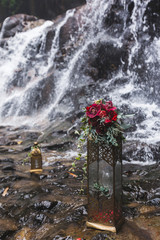 Wedding flower decorations with pink and red orchids, green leaves, bouquet close-up on waterfall