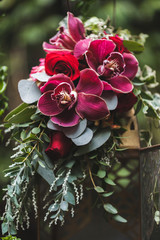 Wedding flower decorations with pink and red orchids, green leaves, bouquet close-up