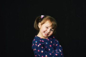 portrait of cheerful little girl on dark background