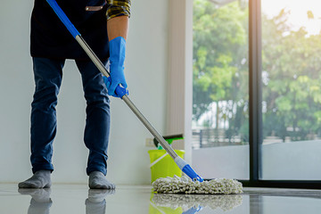 Cleaning Service concept. Cleaners employee removing dirt with equipment in office.