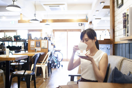 カフェのソファーでまったりコーフィーを楽しむ女性