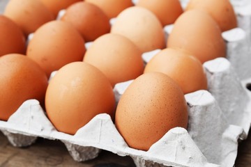 brown chicken egg yolk in shell and eggs in carton