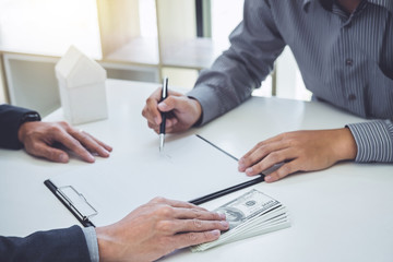 Man customer signing buying home policy document agreement, successful loan contract and salesman receive money after good deal