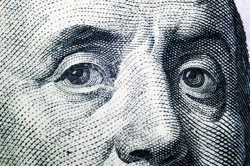 Close up view Portrait of Benjamin Franklin on the one hundred dollar bill. Background of the money. 100 dollar bill with Benjamin Franklin eyes macro shot.