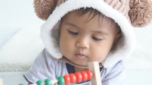 Cute little baby boy play wooden toy