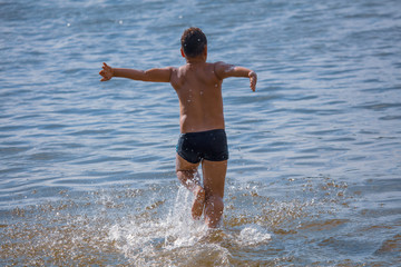 The boy is swimming on the beach