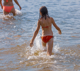 The girl is bathing on the beach