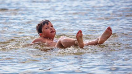 The boy is swimming on the beach