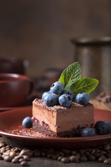 Chocolate cake with blueberries and mint .