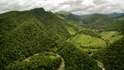 Aerial view of a village in the lush green rain cloud cover tropical rain forest mountain during the rainy season on the Doi Phuka Mountain reserved national park the northern Thailand