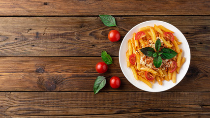 Pasta bolognese with tomato sauce and minced meat, grated parmesan cheese and fresh basil - homemade healthy italian pasta on rustic wooden background. Flat lay. Top view.