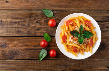Pasta bolognese with tomato sauce and minced meat, grated parmesan cheese and fresh basil - homemade healthy italian pasta on rustic wooden background. Flat lay. Top view.