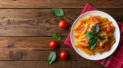 Pasta bolognese with tomato sauce and minced meat, grated parmesan cheese and fresh basil - homemade healthy italian pasta on rustic wooden background. Flat lay. Top view.