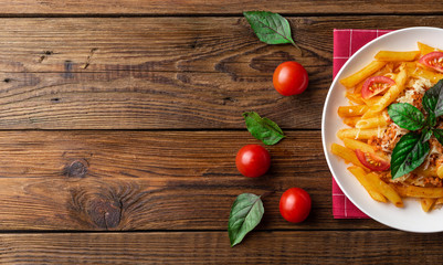 Pasta bolognese with tomato sauce and minced meat, grated parmesan cheese and fresh basil - homemade healthy italian pasta on rustic wooden background. Flat lay. Top view.