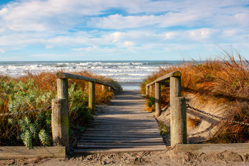 A boardwalk leads over the sand dunes to the beach beyond 