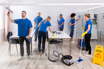Group Of Skilled Janitors Cleaning Office