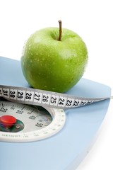 A Green Apple and a Measuring Tape on a Weight Scale