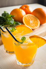 Photo of fresh orange juice in the glass jar. Summer healthy organic drink concept. Cold beverages with ice and orange fruits.