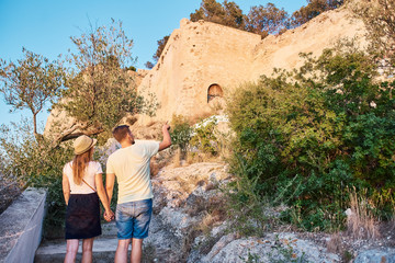 Naklejka premium Happy young couple of travellers holding map in hands