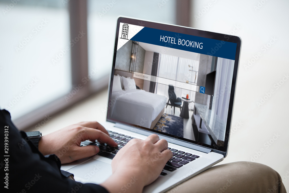 Wall mural man working on laptop, searching for lodging using on-line web service, booking a hotel on website a