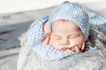 Fototapeta na wymiar Sweet newborn baby sleeps. Newborn boy folded handles in a basket. Close up image