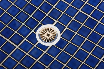 Closeup of a drain hole in shower room.