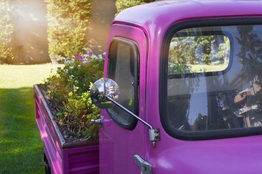 Pink three-wheeled vehicle in vintage garden