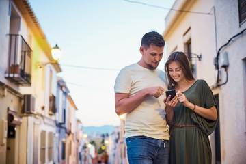 Urban photo of young adult couple looking at cellphone