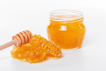 jar of honey and stick isolated on white background