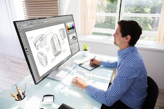 Designer drawing suitcase on computer using graphic tablet
