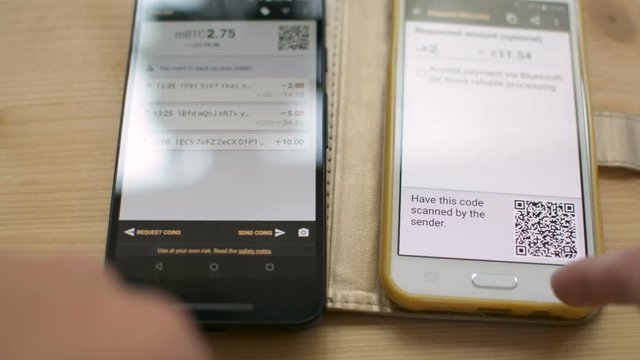Dinishing Bitcoin transaction between smartphones, recieving funds, future of retail, digital cash concept