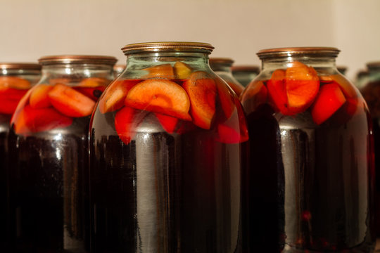 Delicious homemade canned fruit compote in the cellar on the shelf for the winter. Compot from apple and black currant. Closeup, selective focus