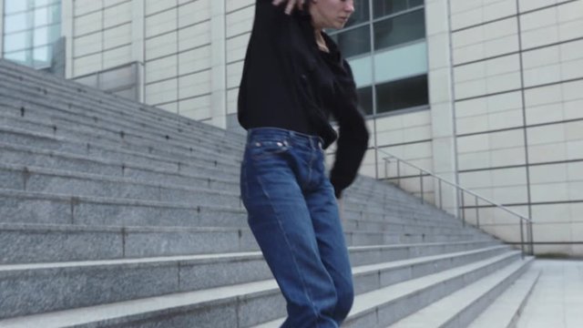 Young Woman Dancing on Office Building Steps