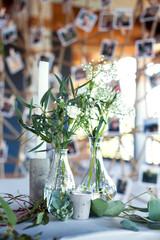 Wedding. Banquet. Table for guests, covered with a tablecloth, decorated with candles, transparent glass vases, fresh flowers and served with cutlery and crockery with rope decorations on background