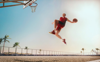 Streetball. Basketball player in action on sunset.